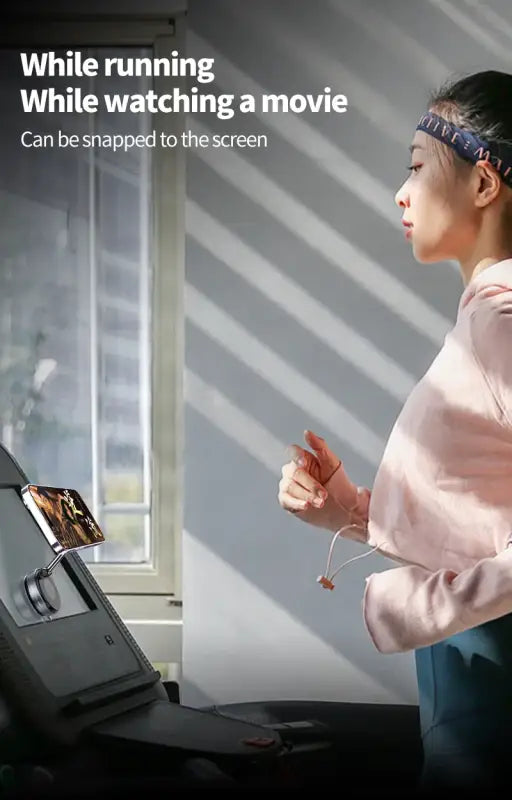 Person using a device with a screen, possibly for fitness tracking or entertainment, in a home setting.