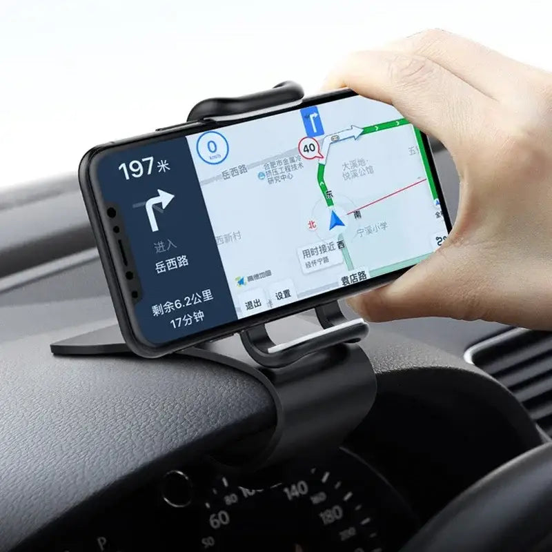 Hand holding a smartphone with navigation app on a car dashboard
