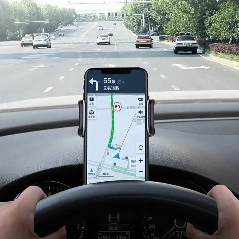 Person driving a car with a smartphone displaying a navigation app on the dashboard.