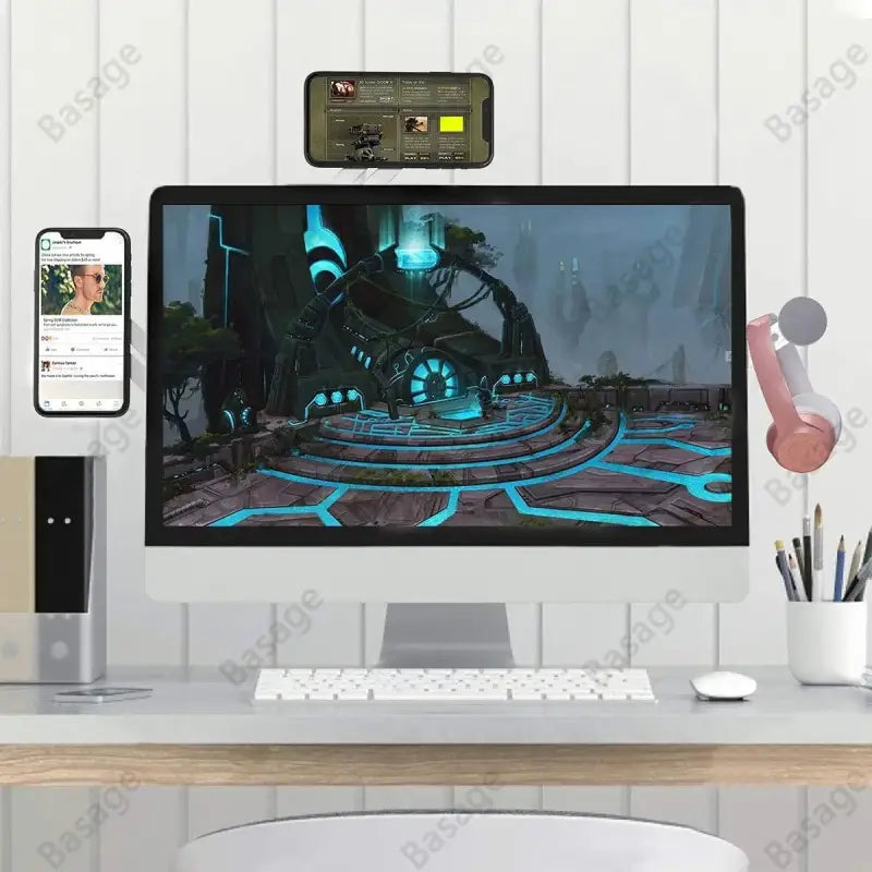 Modern office desk setup with computer monitor, keyboard, and smartphone displaying a video.